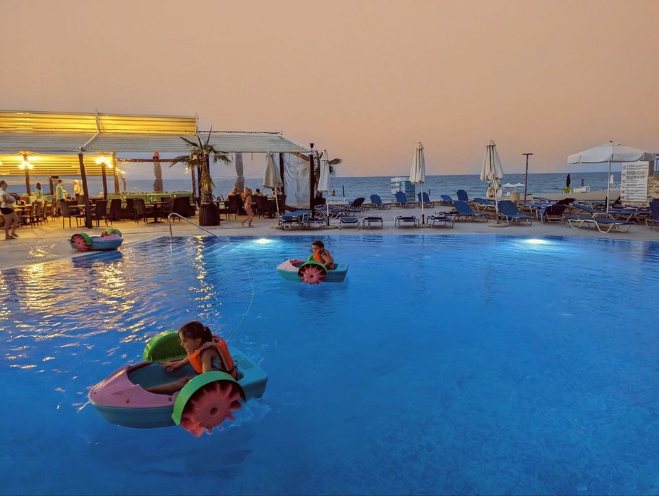 Kind im aufblasbaren Boot im Kinderpool