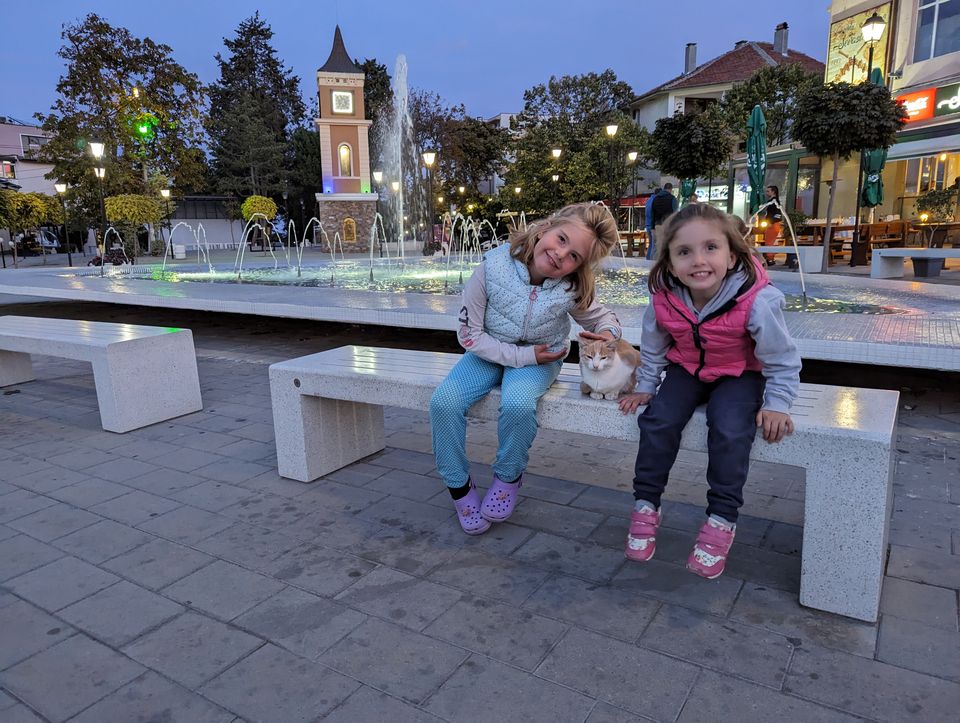 Springbrunnen und beleuchteter Uhrturm im Zentrum von Obzor am Abend