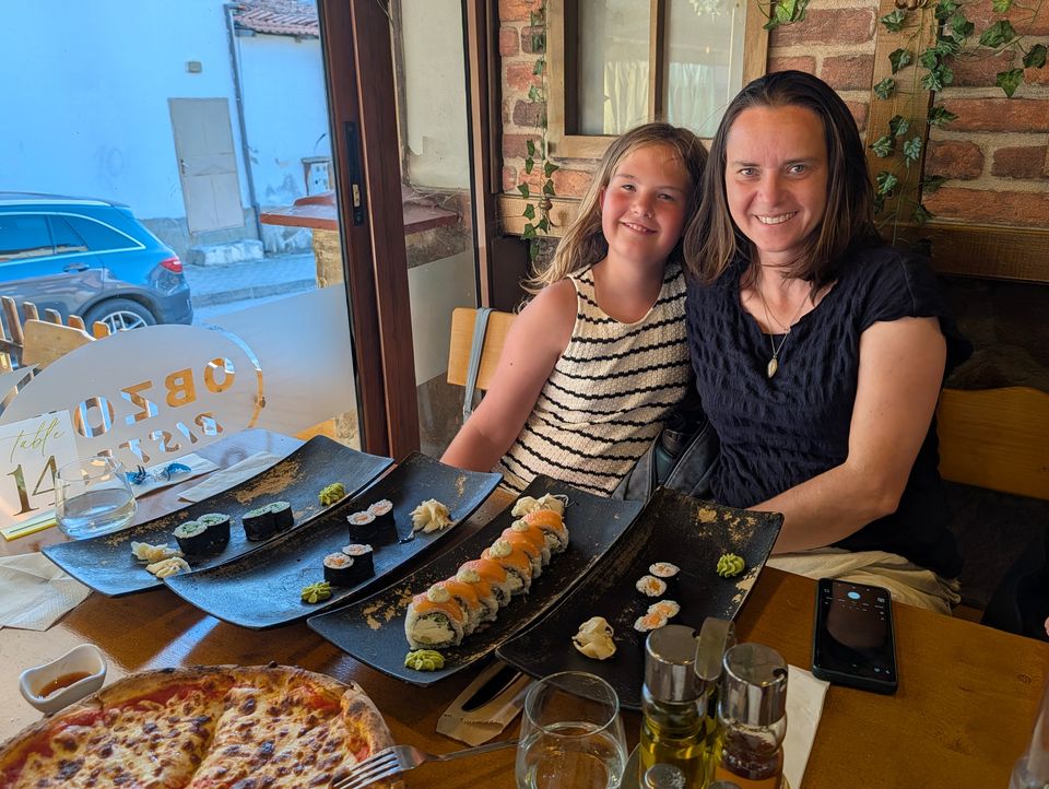 Sushi-Platten und Pizza auf dem Tisch eines Restaurants in Obzor