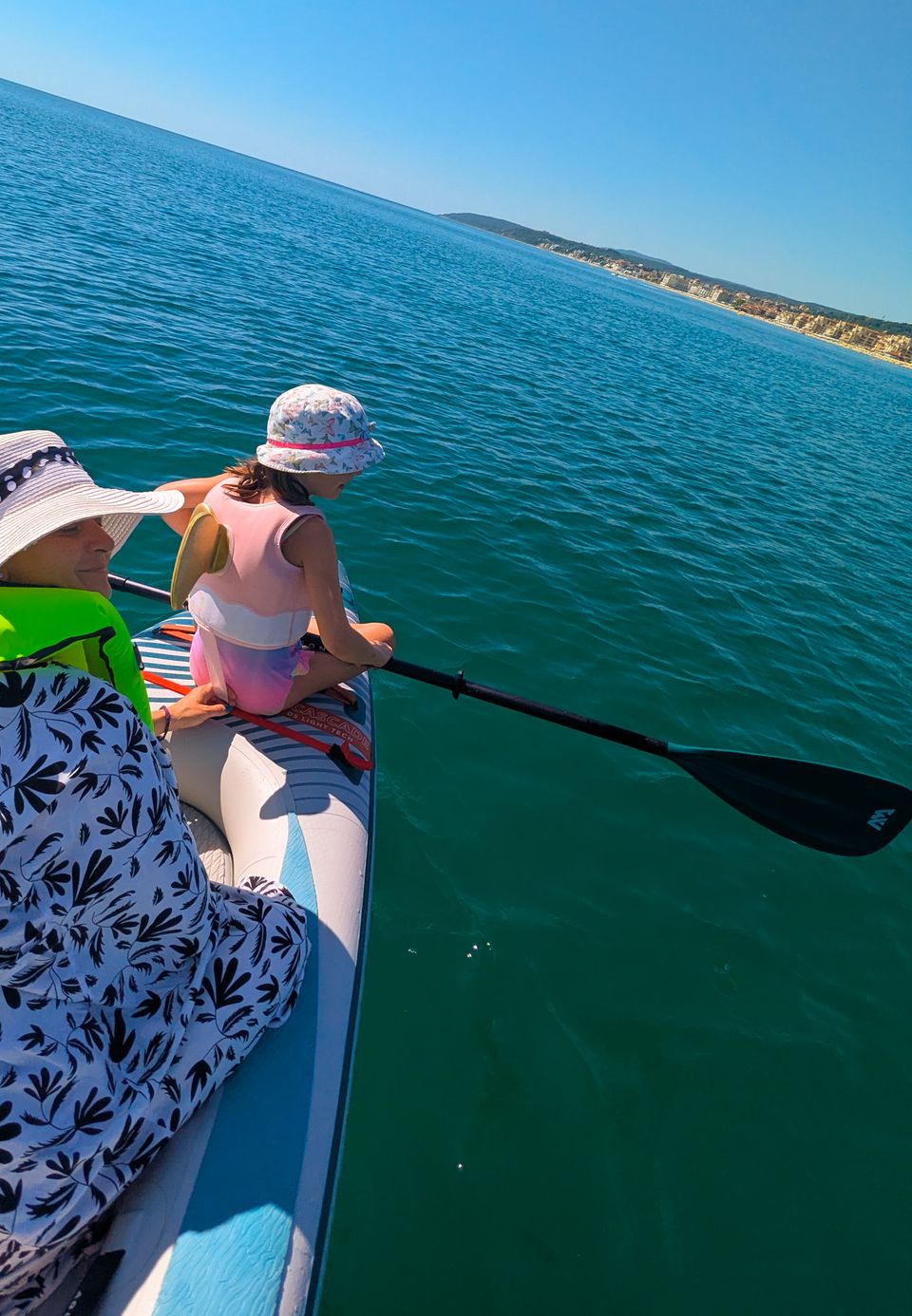 Erwachsene und Kind auf einem SUP-Board auf dem ruhigen Meer vor Obzor