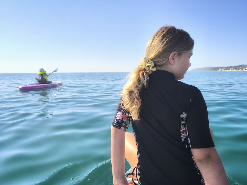 Zwei Kinder auf einem SUP-Kanu im Schwarzen Meer bei Obzor am frühen Morgen